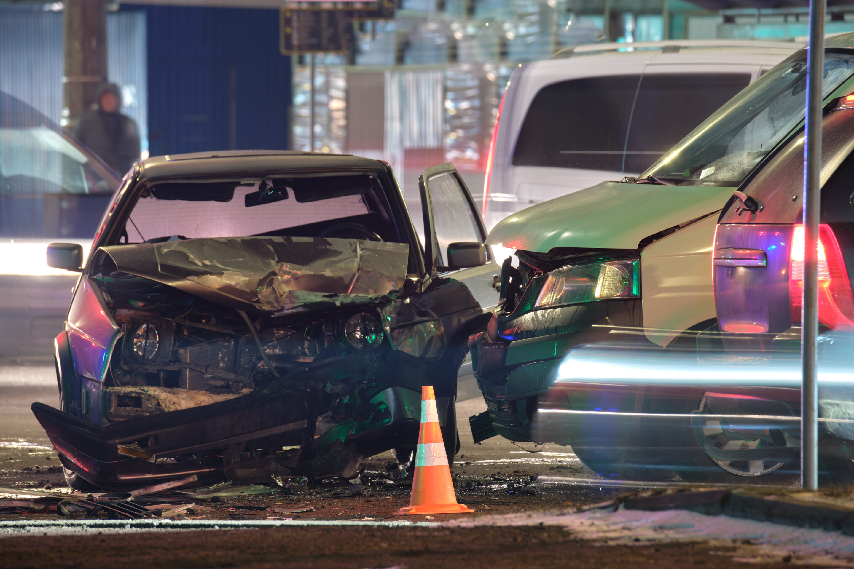 Damaged in heavy car accident vehicles after collision on city street crash site at night Road safety and insurance concept