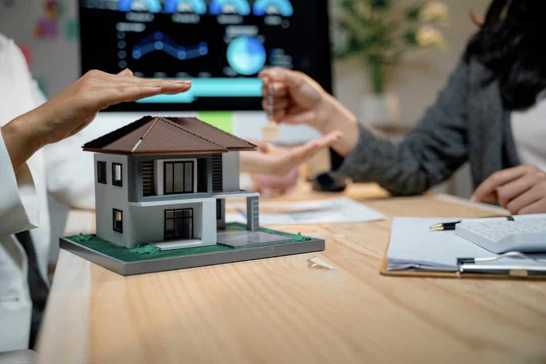 Real estate agent protecting house model and giving keys to client