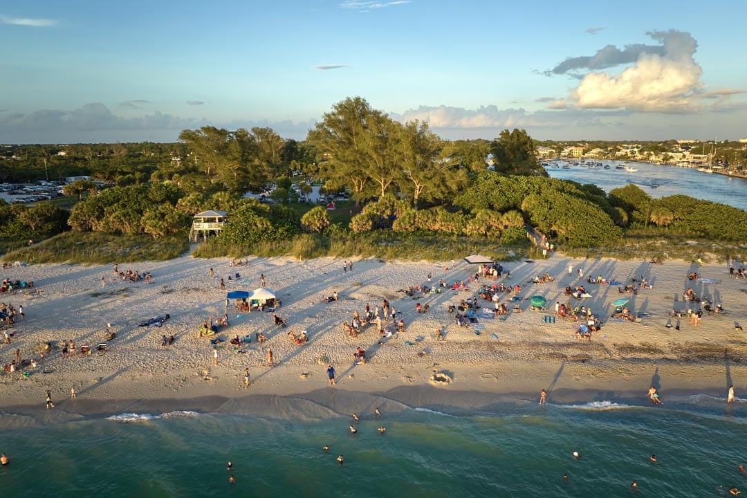 High angle view of crowded Nokomis beach in Sarasota County USA Many people enjoing vacations time swimming in ocean water and relaxing on warm Florida sun at sundown Casey Key Personal Injury
